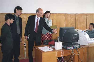 IMF Treasury advisor Janis Platais (center) demonstrates the use of the single-account network at a local government office in Mongolia. Japanese officials (left) and local staff look on.