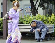 日本－ホームレスの男性の前を通りすぎる女性。アジアでは高成長が貧困を削減したが、同時に不平等も拡大した　（写真： Corbis/Haruyoshi Yamaguchi 
