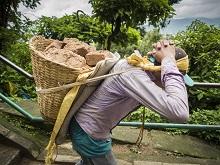 A laborer carries brick from a damaged building.  Nepal is rebuilding with overseas support  (photo: Jack Kurtz/Zuma Press/Corbis) 