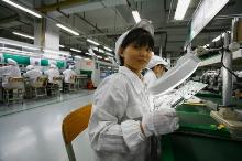 Работница на заводе электроники в Гуандуне, Китай. Содействие включению женщин в состав рабочей силы будет стимулировать всеобъемлющий рост, — отмечает Лагард (фото: Bobby Yip/Corbis). 