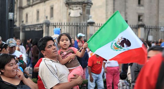 Pai e filha em uma comemoração no Zócalo na Cidade do México, México, onde as políticas sociais ajudaram muitas famílias (foto: erlucho/iStock by Getty Images)