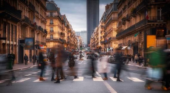 Image of blurred silhouettes crossing a street in Paris