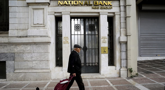 Un transeúnte pasa frente al National Bank, Grecia. Los bancos griegos han mejorado sus niveles de liquidez, la calidad de los activos y la gestión de gobierno (foto: Michalis Karagiannis/Newscom)