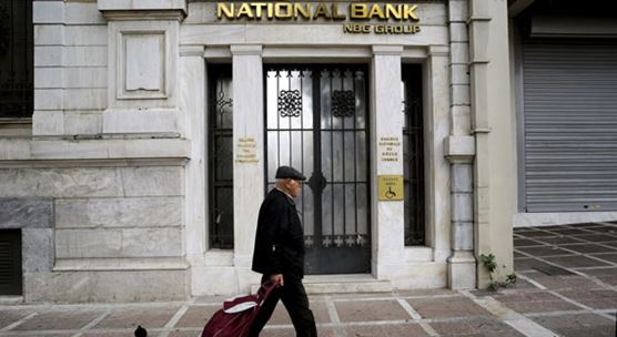 Man walks past National Bank, Greece.  Greek banks have improved their liquidity, asset quality, and governance  (photo: Michalis Karagiannis/Newscom)