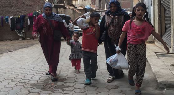 Deux femmes retournent chez elles après avoir reçu un sac lors de la distribution d’aliments de base dans le cadre des efforts de mobilisation des électeurs pendant les deux derniers jours de la présidentielle égyptienne de 2018, dans les quartiers de classe moyenne de Meet Oqba et Ard al-Lewa, situés dans le centre de Giza, le 28 mars 2018 (photo : Islam Safwat/NurPhoto/Sipa USA)