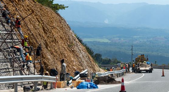 Workers build an anti-landslide concrete wall on a Jamaican highway: infrastructure spending has gained momentum during the country's economic reform program (photo: iStock/Debbie Ann Powell)