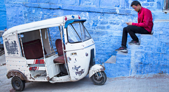 Young man texting next to a rickshaw in Jodhpur, India. Financing new social initiatives and development projects will benefit India’s younger generations, but will require prudent use of public funds (photo: Xavier Arnau, istockphotos) 