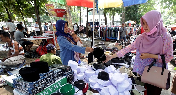 Vendor sells hats in downtown market in Jakarta, Indonesia. Private consumption is a large driver of economic growth for the country, says IMF (photo: Bagus Indahono/EPA/Newscom) 