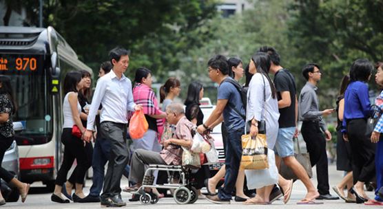 Pedestrians cross a busy street in Singapore: ASEAN countries, of which Singapore is a member, continue to generate strong growth, according to the IMF's latest regional report (photo: Calvin Wong/Newscom).