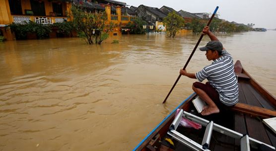 A man rides a boat along the overflowing Thu Bon river in Hoi An after typhoon Damrey hits Vietnam: the effects of climate change are intensifying extreme weather events in the country (photo: Kham/Reuters/Newscom)