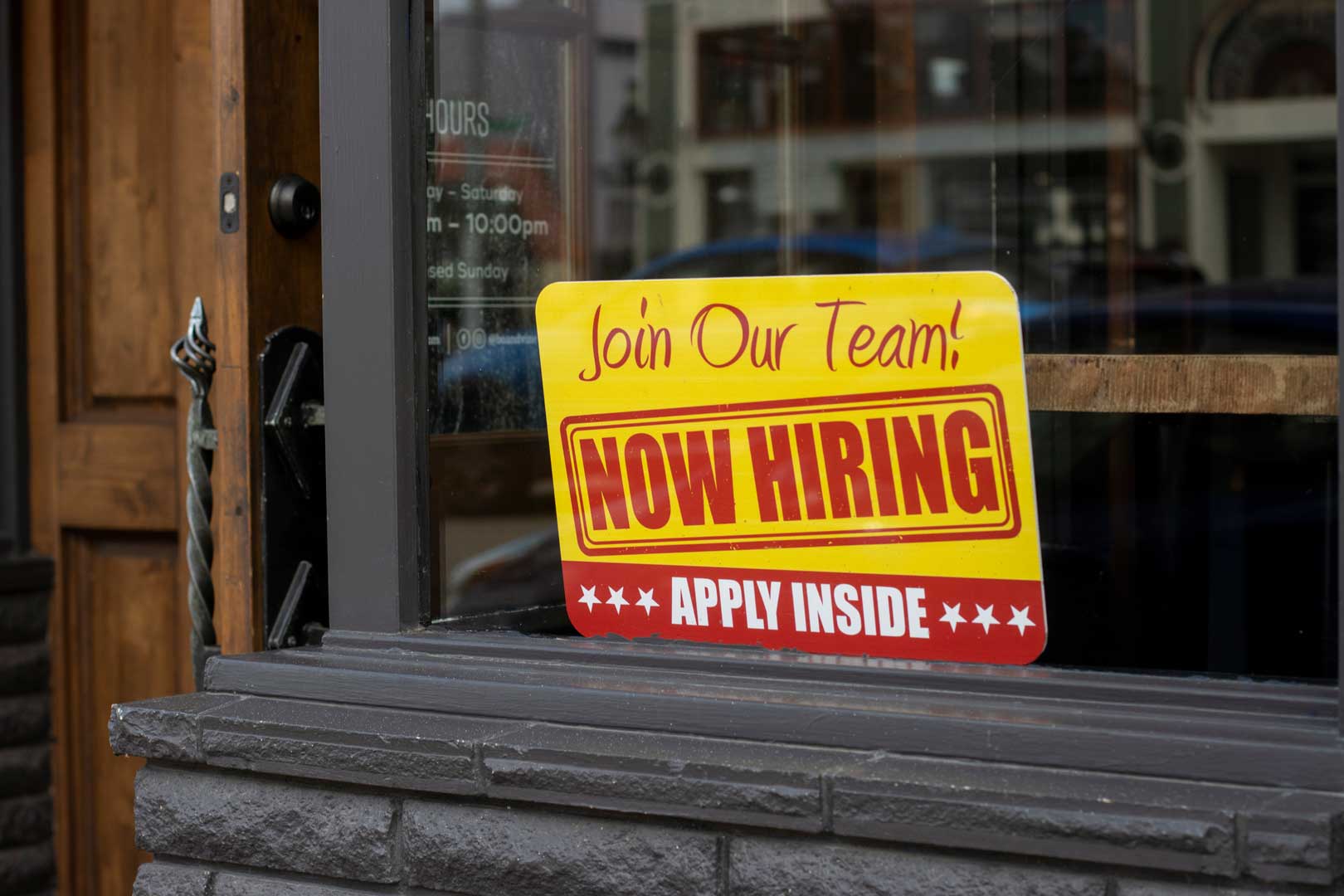 The Now Hiring sign is visible at the storefront