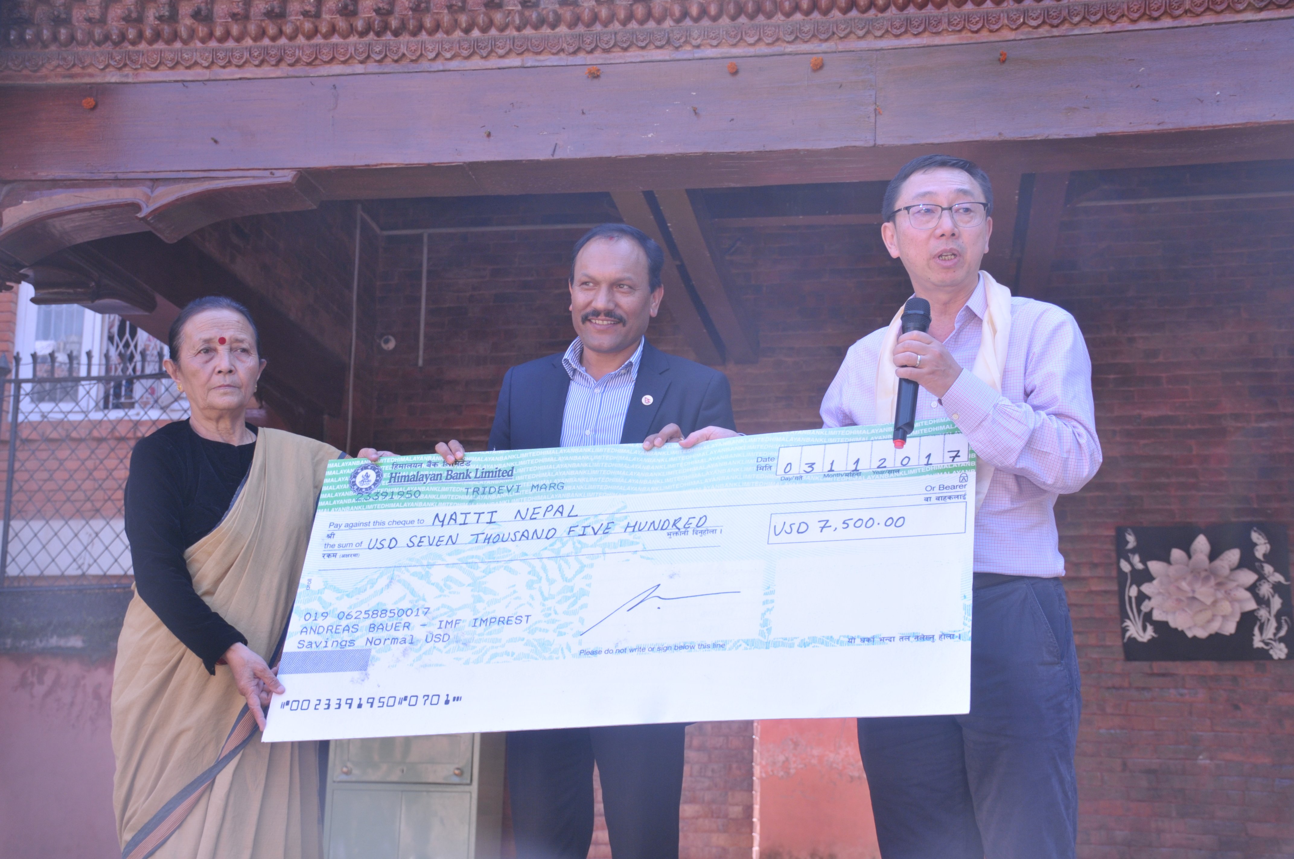 Tao Zhang handing over the Fund’s Civic Fund donation to Maiti