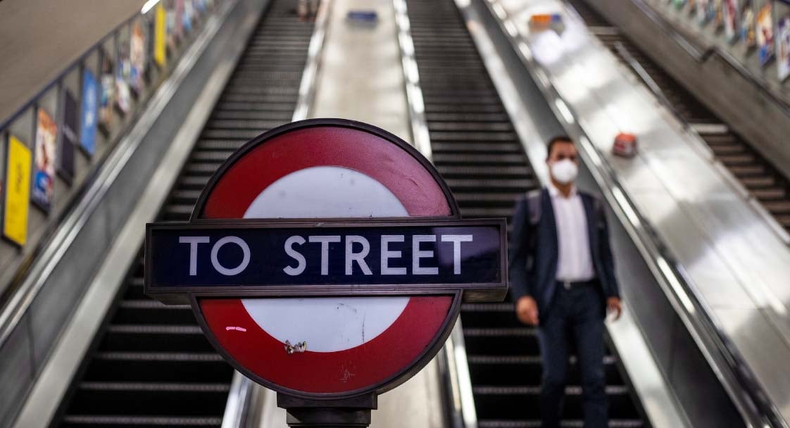 A masked commuter on the escalator at Holborn Underground Station. (IMF Photo/Jeff Moore)
