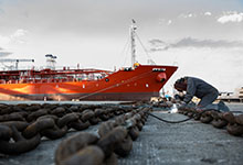 停泊中の船の係留チェーンを溶接する溶接工。IMFの新研究は為替相場が依然輸出入に大きな影響を及ぼすことを確認した。（写真：Leon Sosra/Corbis） 