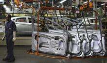A Brazilian worker stands next to car doors at a car plant near Sao Paulo. The IMF says fiscal vulnerabilities have increased in emerging economies over the past year (photo: Nacho Doce/Newscom) 