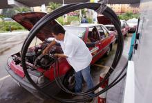 Malaysia taxi driver fills car with natural gas.  Malaysia is a large net exporter of natural gas and other commodities (photo: Stringer/Malaysia/Reuters/Corbis). 