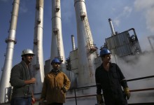 Iranian oil workers gather at Tehran's oil refinery. The recent lifting of sanctions will help increase oil production in Iran and lower trading costs. (Photo: AP Photo/Vahid Salemi) 