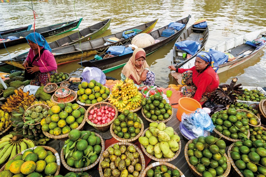 Women selling fruit at a waterside market