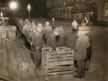 Unemployed men wait in line for bread during the Depression in the United States.
