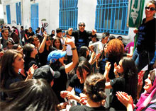 Students celebrating the end of exams by dancing in the street in front of their school in Tunis, Tunisia.