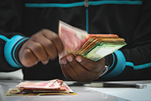 An employee counts currency at a bank branch in Johannesburg, South Africa.