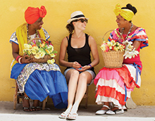 Tourists with traditional flower ladies in Old Havana, Cuba.