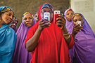 Members of the Mada Saving Club in Tsafe, Nigeria, checking their cell phones.