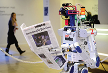Robot holds newspaper during 2016 World Economic Forum, Davos, Switzerland.