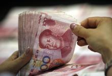 银行出纳员在点数人民币钞票：基金组织执董会已认定中国人民币“可自由使用”（图片：Imaginechina/Corbis） 