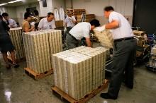 Bank of Japan employees stack newly printed money. The central bank has taken the lead in ending deflation through monetary easing (photo: TWPhoto/Corbis) 