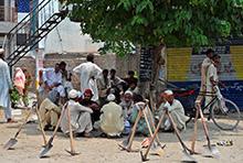 Pakistani laborers sit underneath the shade as they await work. The IMF-supported program includes reforms that will help boost growth and create jobs (photo: Farooq Naeem/AFP/Newscom) 