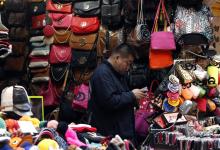 Man checks his mobile phone near a vendor stall in Seoul. For more balanced  growth, Korea needs to address low productivity in the services sectors (photo: Kim Hong-Ji/Reuters/Corbis) 